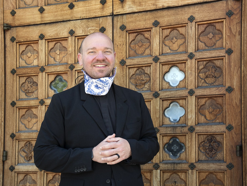 Father Andy poses in front of the door to St. Brigid of Kildare Church.