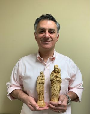 Christians of the Holy Land founder Rami Qumseih holds two St. Joseph statues, which are available for purchase in two sizes. He is raising support for the St. Joseph Project which seeks to provide work for Christian carvers in the Holy Land who have been unemployed since the pandemic hit in March 2020.